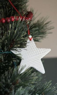 a white star ornament hanging from a christmas tree with the words better than salt dough ornaments