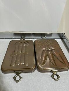 two metal trays sitting on top of a white table next to an open box