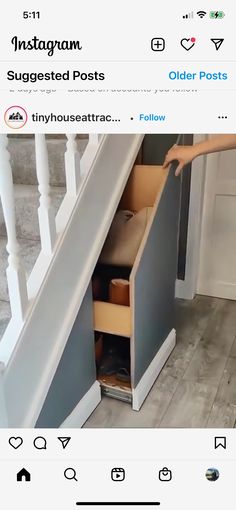 an open drawer under the stairs is shown on this instagram page, and it appears to be someone's hand reaching for something