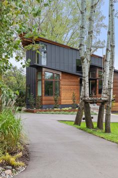 the house is surrounded by tall trees and has a walkway leading up to it's entrance