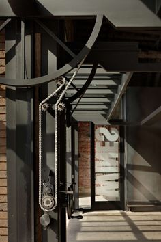 an old clock hanging from the side of a building next to a brick wall and door