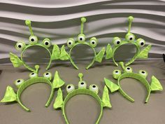 a group of green headbands with eyes and ears on top of a table