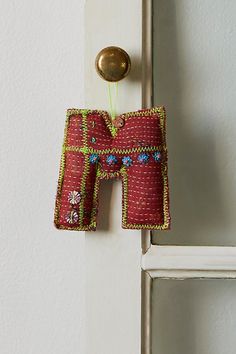 an ornament hanging from the side of a white door with a gold handle