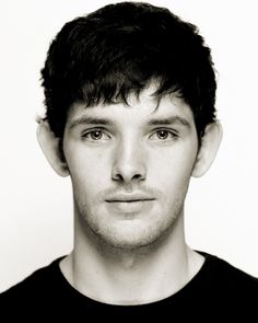 a close up of a person with short hair and blue eyes looking at the camera