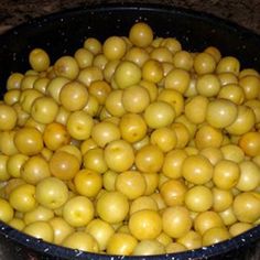 a black bowl filled with lots of yellow fruit