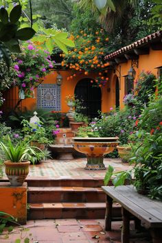 an orange walled courtyard with potted plants and flowers on the steps leading up to it