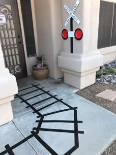 a street sign on the sidewalk in front of a house with rocks and gravel around it