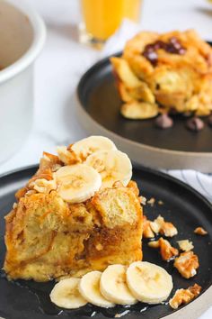 two black plates topped with banana french toast and sliced bananas on top of each other