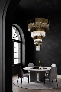 an elegant dining room with black walls and chandelier hanging from the ceiling,