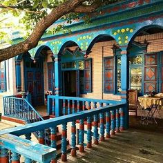 an old house with blue paint and wooden balconies on the front porch area