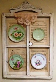 an old window is decorated with plates and flowers