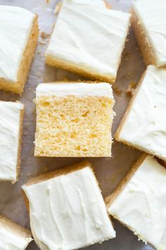 several pieces of white cake sitting on top of a table with frosting and icing