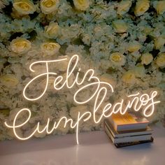 there is a neon sign that says telly cumpleanos next to some books