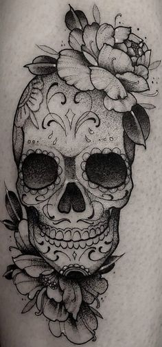 a black and white skull with flowers on it's head is shown in this tattoo design