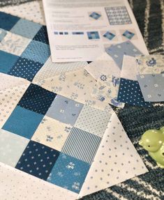 a blue and white patchwork quilt with a green rubber ducky toy on it