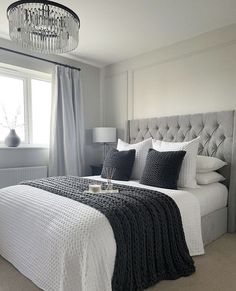 a bedroom with a bed, chandelier and window