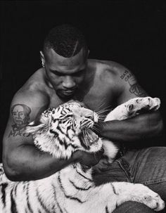 a man holding a white tiger in his arms