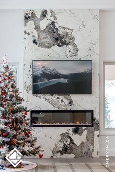 A sparkling Patagonia marble fireplace wall with a Christmas tree & festive decor.