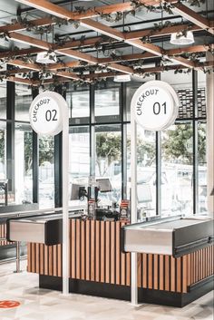 the inside of a restaurant with two counters and three clocks on each side of the counter