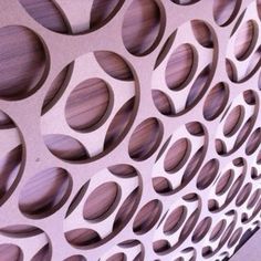 a wall made out of circles and holes on it's side, with wood in the middle