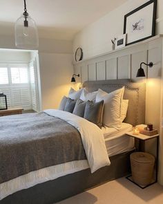 a bedroom with a large bed and two lamps on either side of the headboard