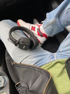 a person sitting in the back seat of a car with headphones attached to their ears