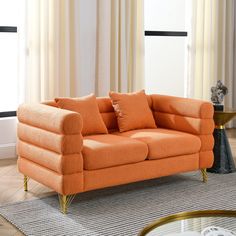 an orange couch sitting on top of a rug