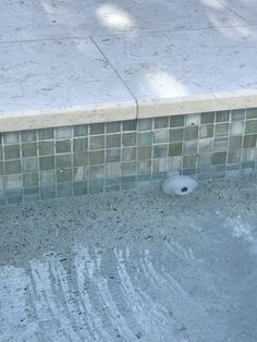 a fire hydrant sitting on the side of a pool next to a tiled wall