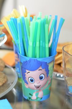 a cup with toothbrushes in it sitting on a table next to crackers