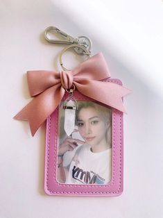 a pink keychain with a bow on it and a photo hanging from the front