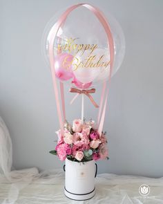 a vase with flowers and balloons in it