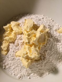 a bowl filled with flour and butter on top of a table