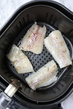 four pieces of fish sitting in an air fryer