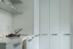 a kitchen with white cabinets and glassware on the counter