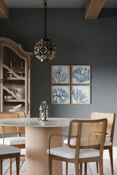 a dining room table with chairs and pictures on the wall