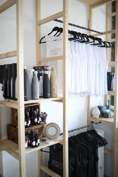 the shelves are full of bottles and other items in this room with clothes hanging on them