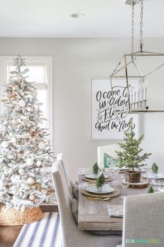 a white christmas tree in the corner of a dining room