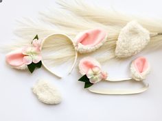 a white headband with pink and white flowers on it next to some hair accessories