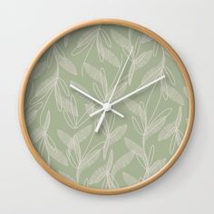 a clock with leaves on it is shown in white and light green color palettes