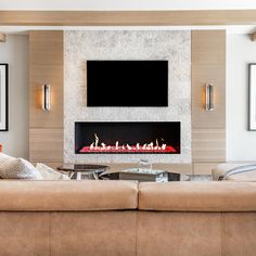 a living room with couches and a fire place in the center, along with a flat screen tv