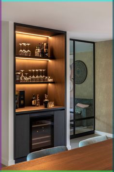 a room with a table, shelves and wine glasses