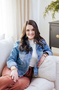 a woman sitting on top of a white couch