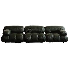 a black leather couch with four seats on the bottom and one arm facing away from the camera