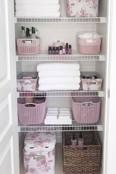 an organized closet with baskets and towels