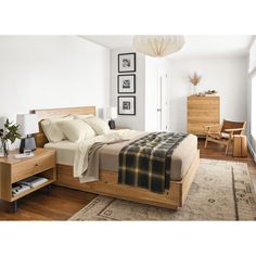 a bedroom with white walls and wooden furniture