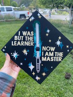 someone holding up a graduation cap that says i was but the learner now i am the master