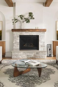 a living room with a fireplace, couches and a coffee table in front of it