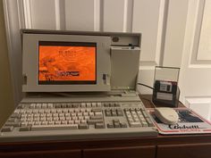 an old computer sitting on top of a wooden desk