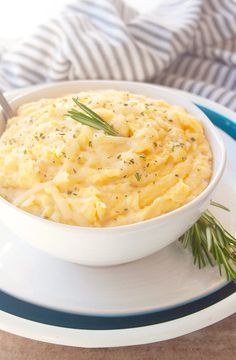 a white bowl filled with mashed potatoes on top of a plate