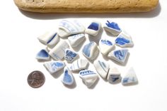 small pieces of blue and white pottery next to a penny